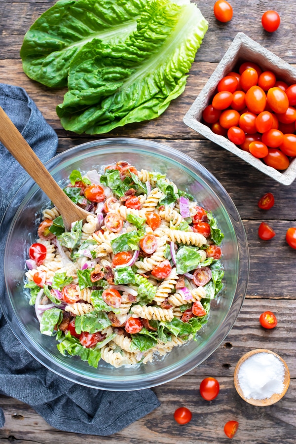 Bacon, lettuce, and tomatoes pasta salad recipe with mayonnaise and Ranch dressing next to a pint of cherry tomatoes.