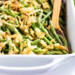 French fried onions on top of fresh green beans in a casserole dish.
