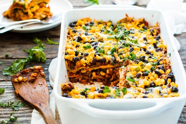 A piece of a ground turkey casserole recipe on a plate in the background of a casserole dish.