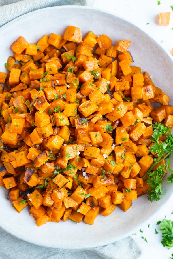 Toasted and roasted sweet potato cubes in a gray bowl.