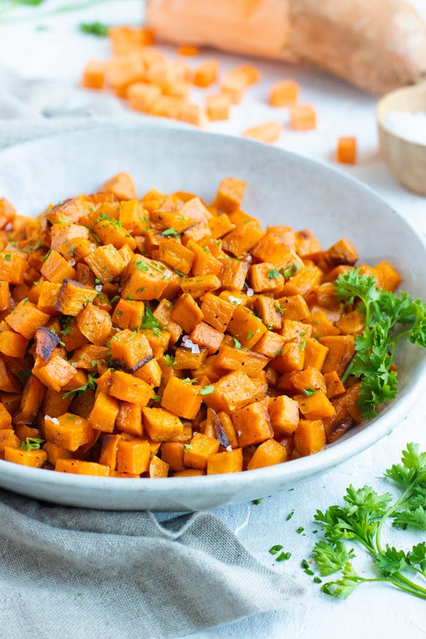 Easy, gluten-free oven roasted sweet potato cubes in a gray bowl.