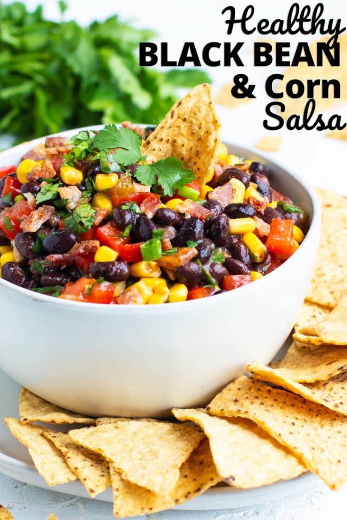 Black bean and corn salsa recipe in a white bowl with corn tortilla chips.
