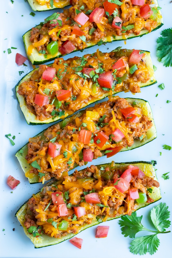 Mexican ground turkey stuffed zucchini boats with tomatoes, cheese, and cilantro.