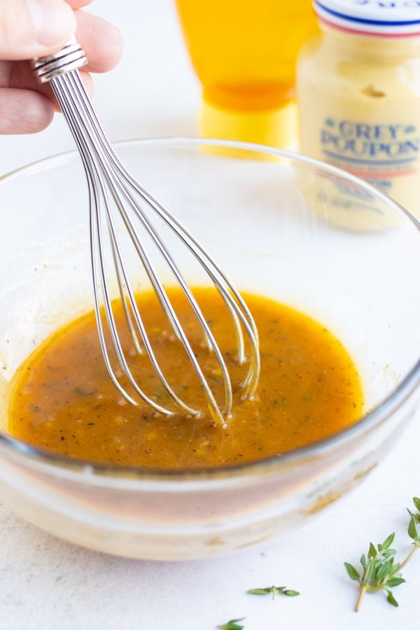 Honey mustard sauce being whisked together in a bowl.
