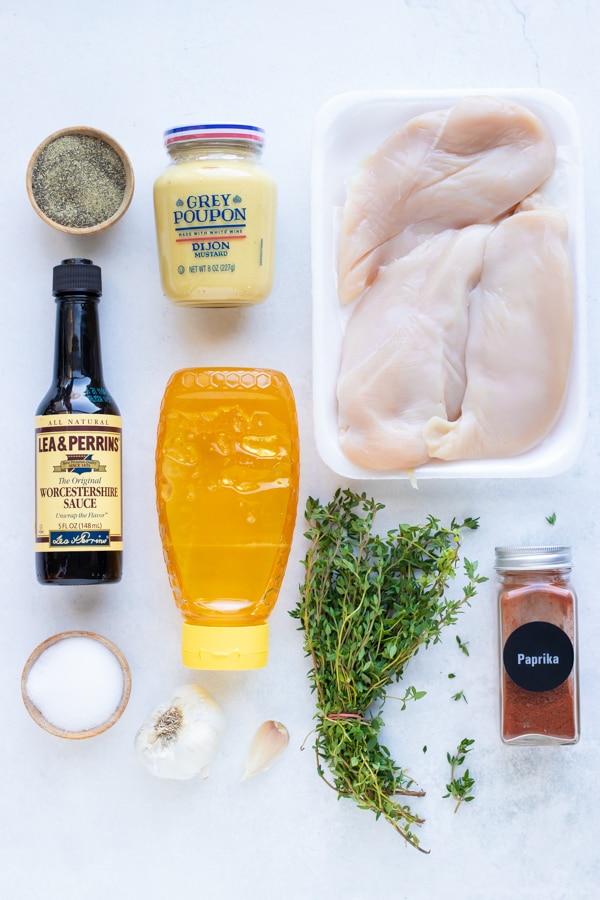 Honey, mustard, thyme, paprika, salt, and garlic as ingredients for a recipe.