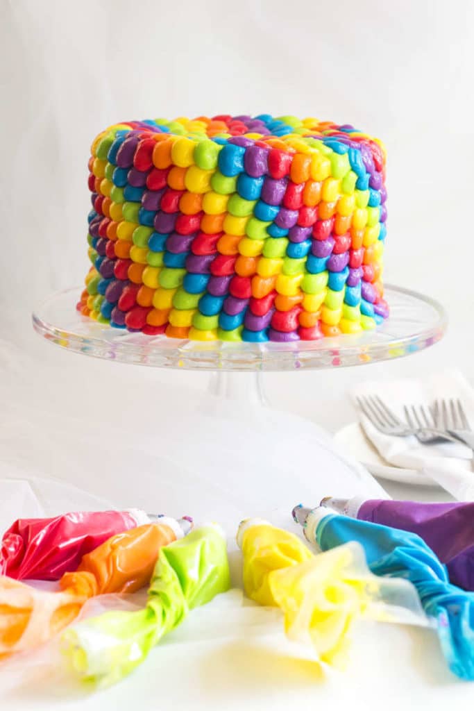 Rainbow Birthday Cake | An impressive rainbow frosted cake that is perfect for any anniversary, birthday or special occasion. A classic vanilla cake recipe is finished off with multi-color buttercream frosting!