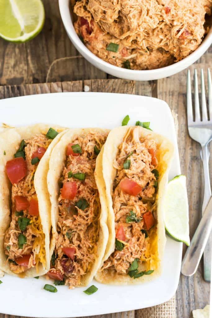Tacos filling a white plate with a salsa chicken recipe in the slow cooker.