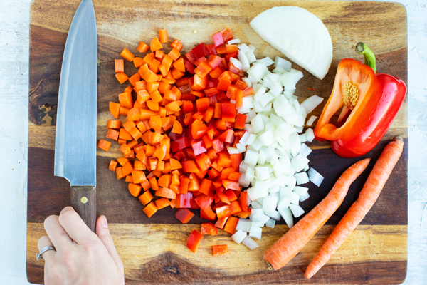 Finely diced carrots, red bell pepper, and sweet onion as ingredients in a gluten-free fried rice recipe.