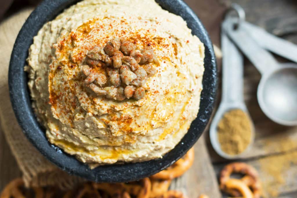 An overhead picture of gluten-free lentil hummus inside a black bowl for a quick appetizer.