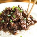 Copycat PF Chang's Mongolian Beef on a bed of rice with chopsticks for lunch.