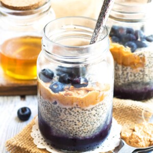 Two jars filled with Peanut Butter and Jelly Chia Pudding using chia seeds with spoons inside.
