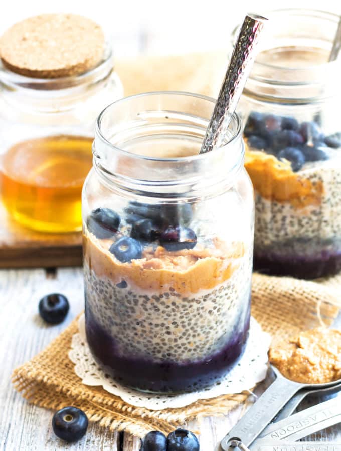 Two jars filled with Peanut Butter and Jelly Chia Pudding using chia seeds with spoons inside.