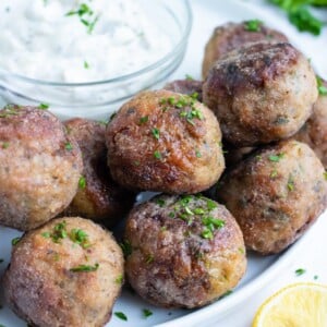Low-carb and gluten-free meatballs are served plain as a dinner or an appetizer with a creamy, greek sauce.