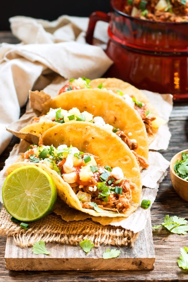 Slow Cooker Pineapple Pulled Pork Tacos RECIPE served with lime and cilantro.