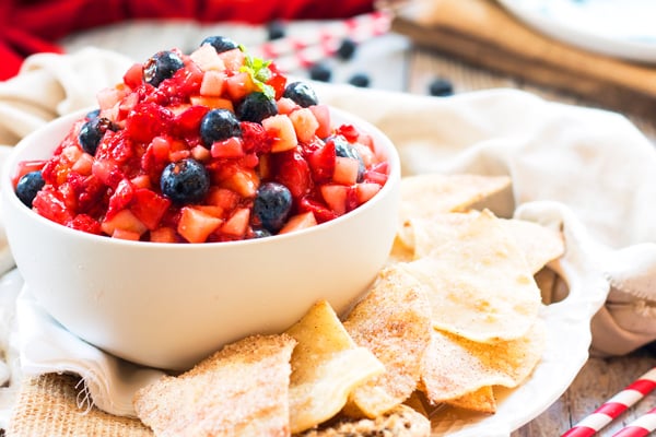 A bowl filled with a gluten-free fruit salsa recipe and cinnamon chips for dipping.