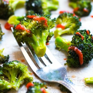 Gluten-free roasted broccoli made with Sriracha and honey on a fork for a healthy side dish.