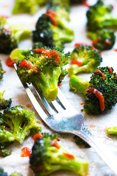 Gluten-free roasted broccoli made with Sriracha and honey on a fork for a healthy side dish.