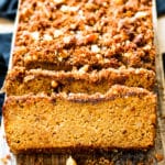 A sliced loaf of gluten-free, healthy pumpkin bread on a piece of wood.