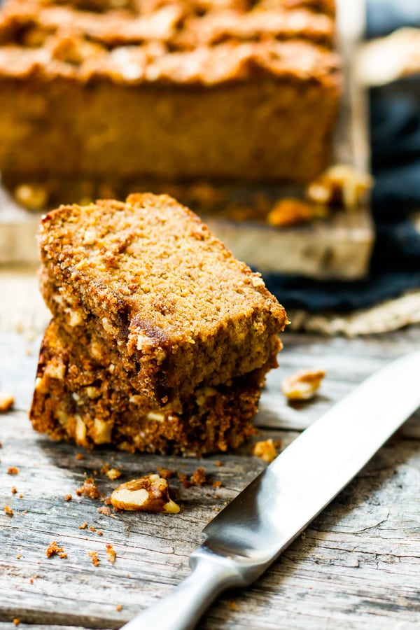 A couple of slices of a pumpkin bread recipe on a table ready to eat.