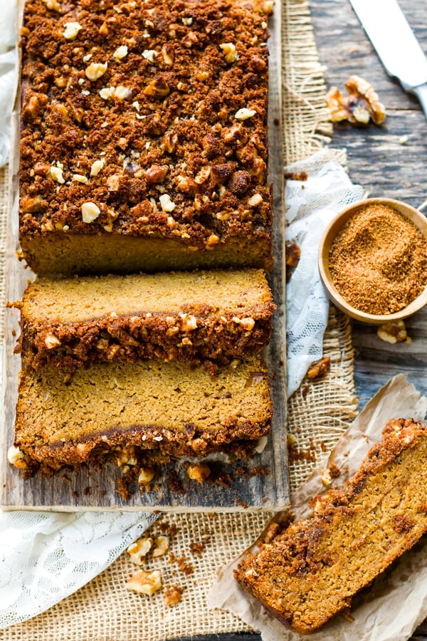 A loaf of gluten-free Coconut Flour Pumpkin Bread with two cut slices ready for a healthy breakfast.