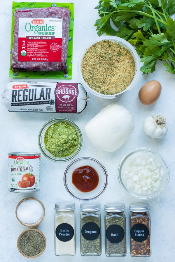 Ground beef, ground sausage, parsley, tomato sauce, breadcrumbs, seasonings, onions, garlic, egg, mozzarella, pesto, and