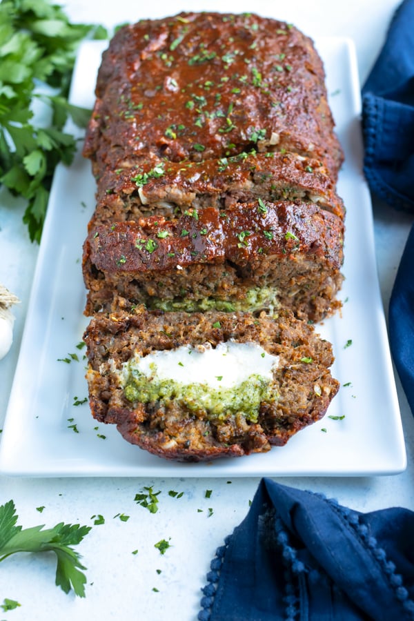 Gluten-free Mozzarella stuffed meatloaf is served on a white platter.
