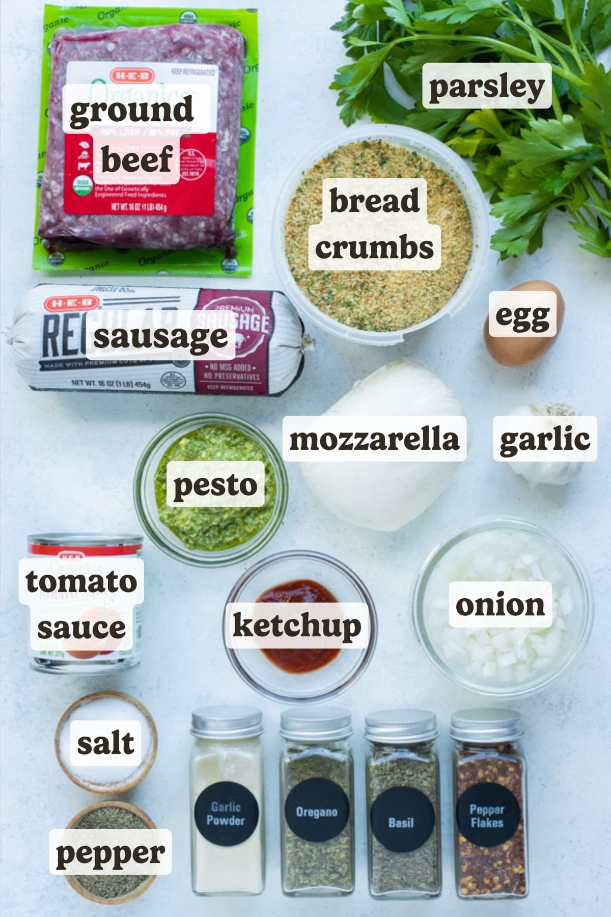 Ground beef, ground sausage, parsley, tomato sauce, breadcrumbs, seasonings, onions, garlic, egg, mozzarella, and pesto are the main ingredients for this meatloaf recipe.
