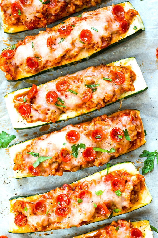 A row of gluten-free Pizza Zucchini Boats made with Pepperoni and Sausage for a healthy lunch.