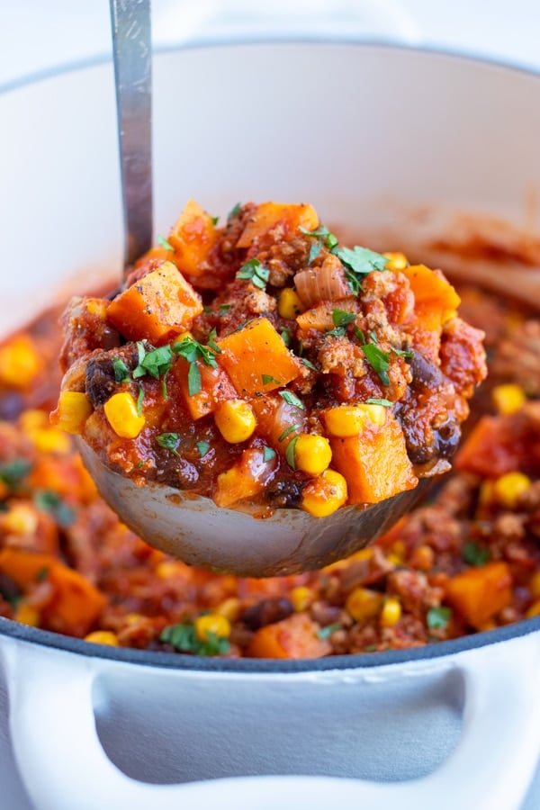 A ladle is used for serving this ground turkey chili with sweet potatoes.