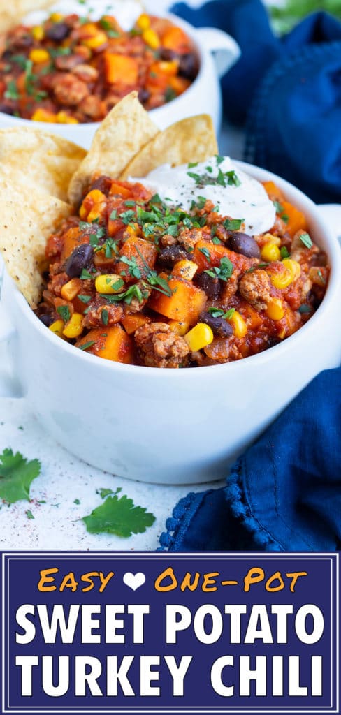 A cozy bowl of ground turkey chili is topped with sour cream for a healthy meal.
