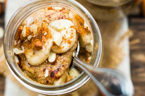 Almond butter overnight oats in a jar with bananas for a vegan breakfast.