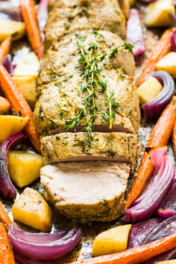 Roasted Pork Tenderloin with Mustard, Apple, and Vegetables on a baking sheet for an easy dinner.