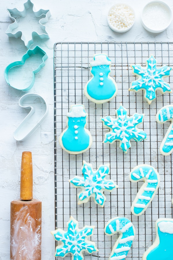 A cut out sugar cookie recipe that do not spread and are made with butter and gluten-free flour.Cut out sugar cookies that do not spread that are on a cooling rack next to a rolling pin and sprinkles.