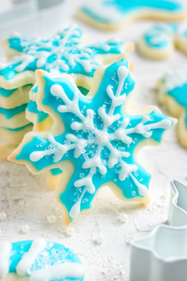 Cut-out sugar cookies in the shape of snowflakes for a Christmas party dessert.