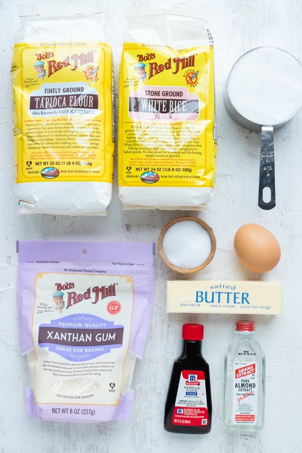 Gluten-free flour, butter, vanilla and almond extract, sugar, butter, and an egg as the ingredients for cut out sugar cookies.