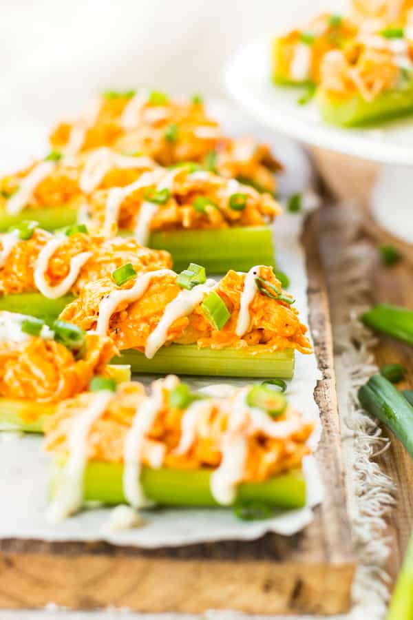 A collection of Buffalo Chicken Celery Sticks with ranch dressing drizzled on top.