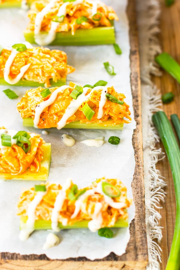 A line of celery sticks containing gluten-free buffalo chicken dip for a healthy appetizer.