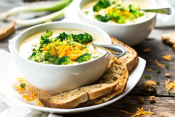 A white bowl filled with gluten-free Crock-Pot Broccoli Cheese Soup for a healthy lunch.
