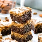 Three German Chocolate Bars in a pile surrounded by almonds.