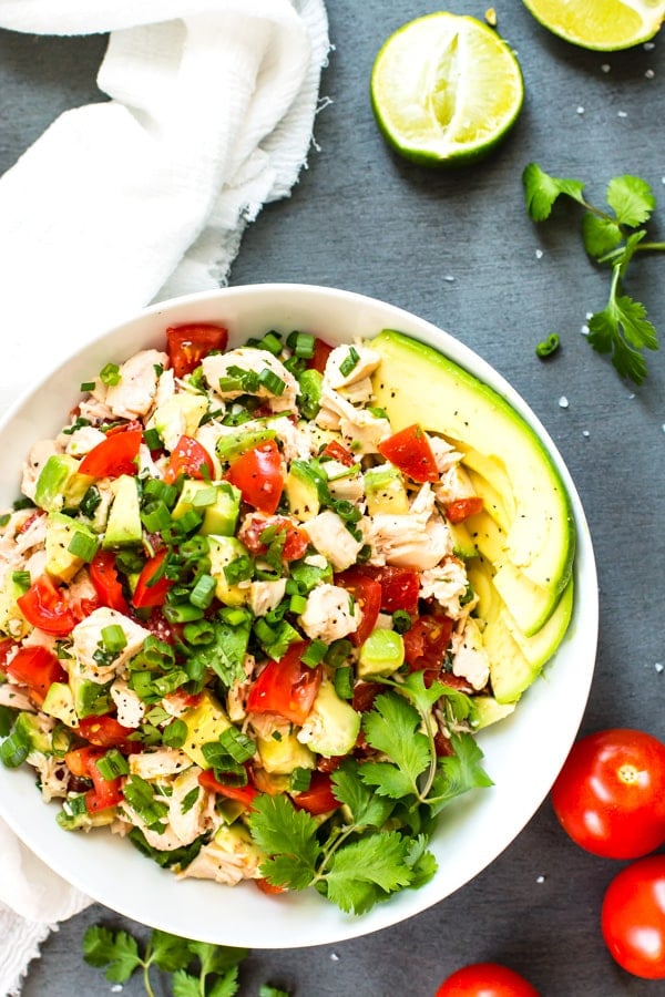 An overhead picture of gluten-free chicken salad with avocados and tomatoes for a healthy lunch.