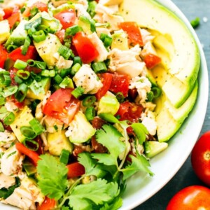 Gluten-free avocado chicken salad recipe in a bowl with tomatoes for a healthy lunch.