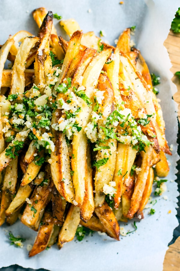 Extra crispy Parmesan garlic fries are baked in the oven, instead of fried, for a healthier french fry recipe! Top them off with a Parmesan, garlic and parsley coating for the ultimate gluten-free and vegetarian side dish recipe.