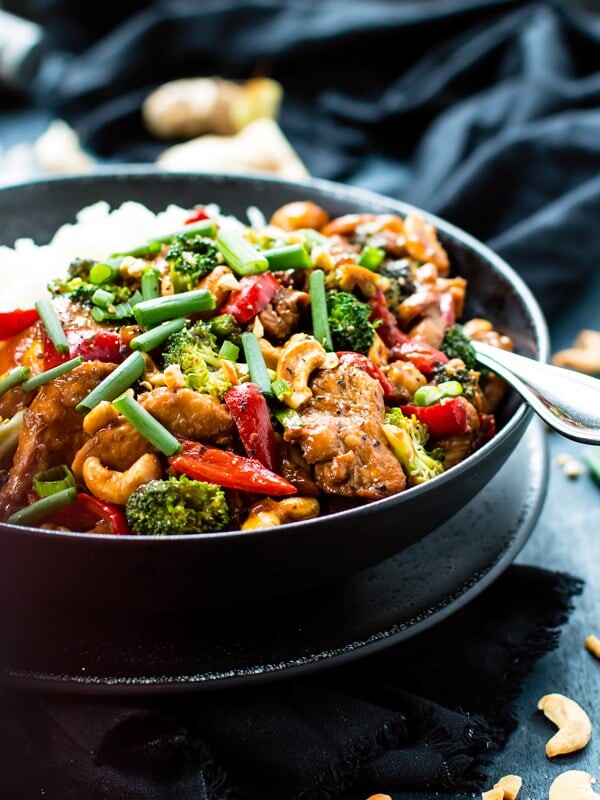 Cashew Chicken Stir-Fry in a bowl with rice and a fork for a healthy lunch.
