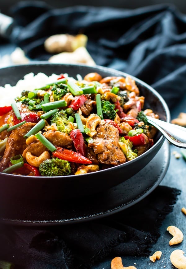 Cashew Chicken Stir-Fry in a bowl with rice and a fork for a healthy lunch.