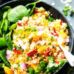 A bowl of gluten-free cold quinoa salad with oranges and spinach for a healthy dinner.
