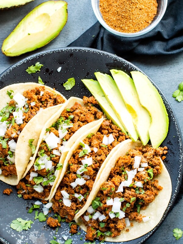 A plate full of gluten-free Ground Turkey Tacos topped with chopped onions for a healthy dinner.