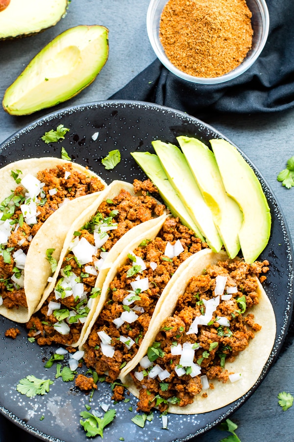 A plate full of gluten-free Ground Turkey Tacos topped with chopped onions for a healthy dinner.