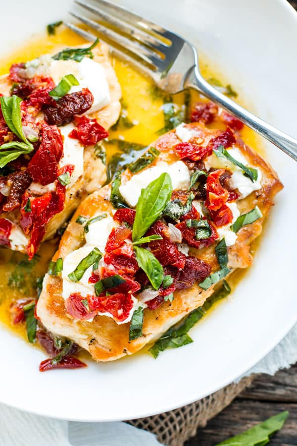 Gluten-free tomato chicken on a white plate with a fork for a healthy lunch.