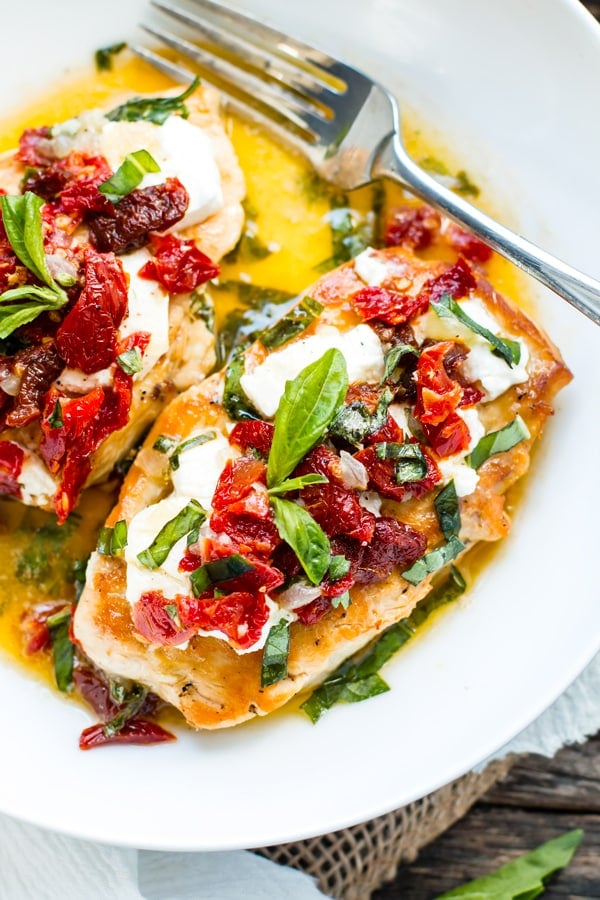 Gluten-free tomato chicken on a white plate with a fork for a healthy lunch.