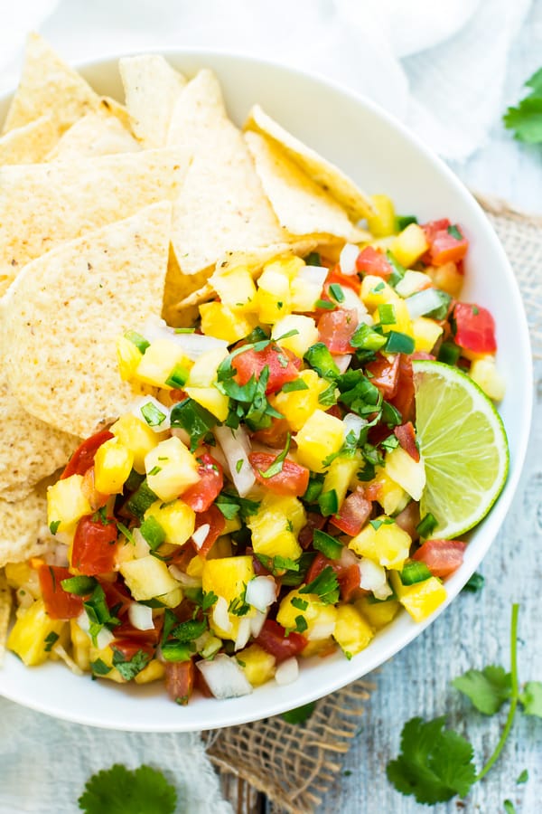 Gluten-free Pineapple Pico de Gallo with tortilla chips in a bowl for a healthy snack.